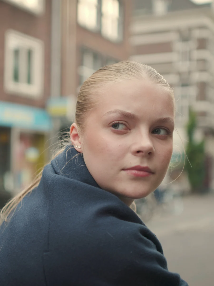 Een vrouw kijkt over haar schouder in een straat in Arnhem