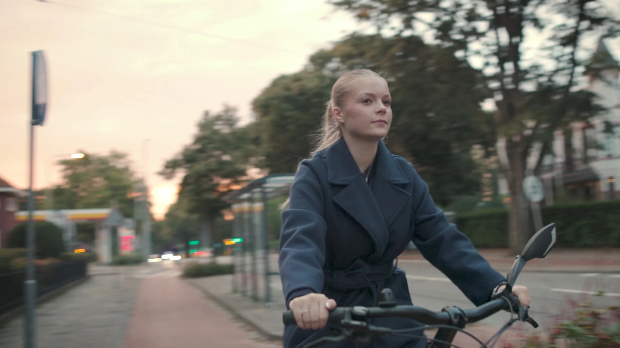 Een vrouw fietst door Arnhem in het avondlicht
