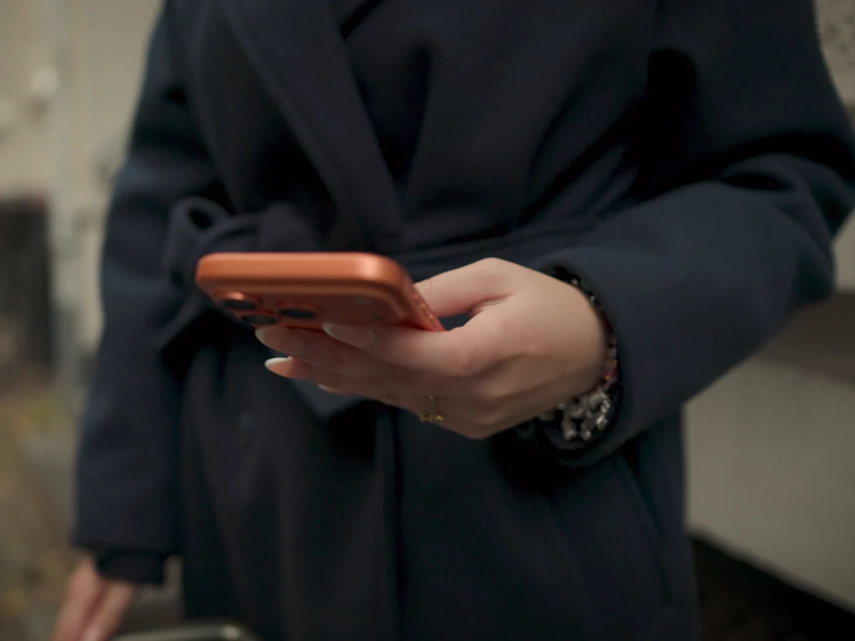 Een vrouw houdt onderweg haar telefoon in haar hand